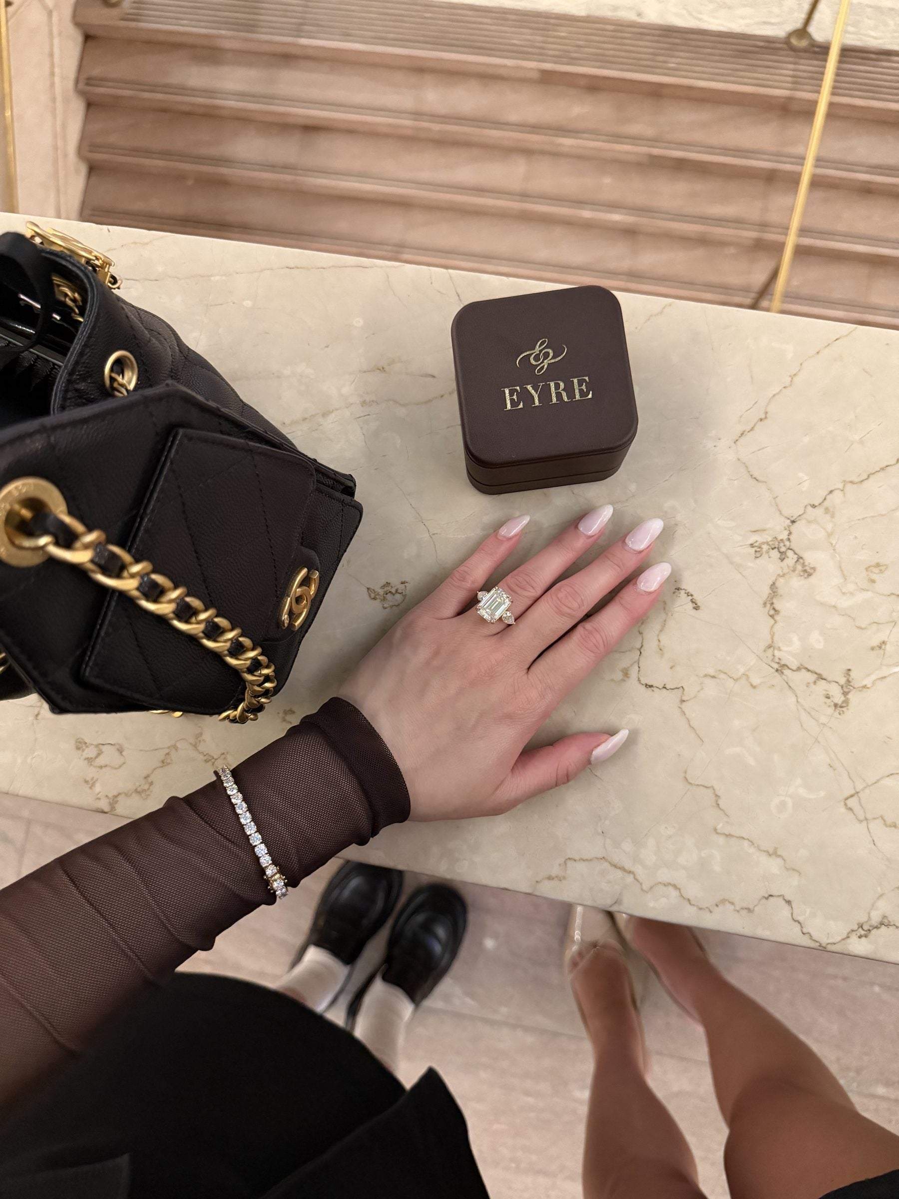 An EYRE ring and tennis bracelet beside the EYRE ring box